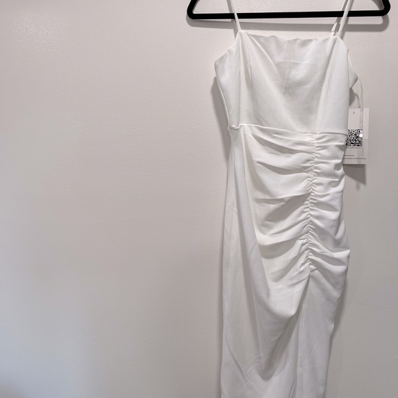 White dress with side ruching, slit and straps in medium.